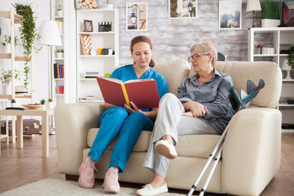 Nurse reading to a senior receiving home health care services.